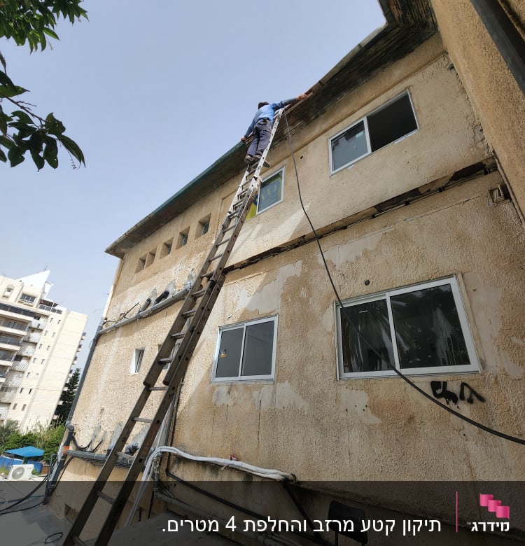 אדם על סולם מתקן גג בניין